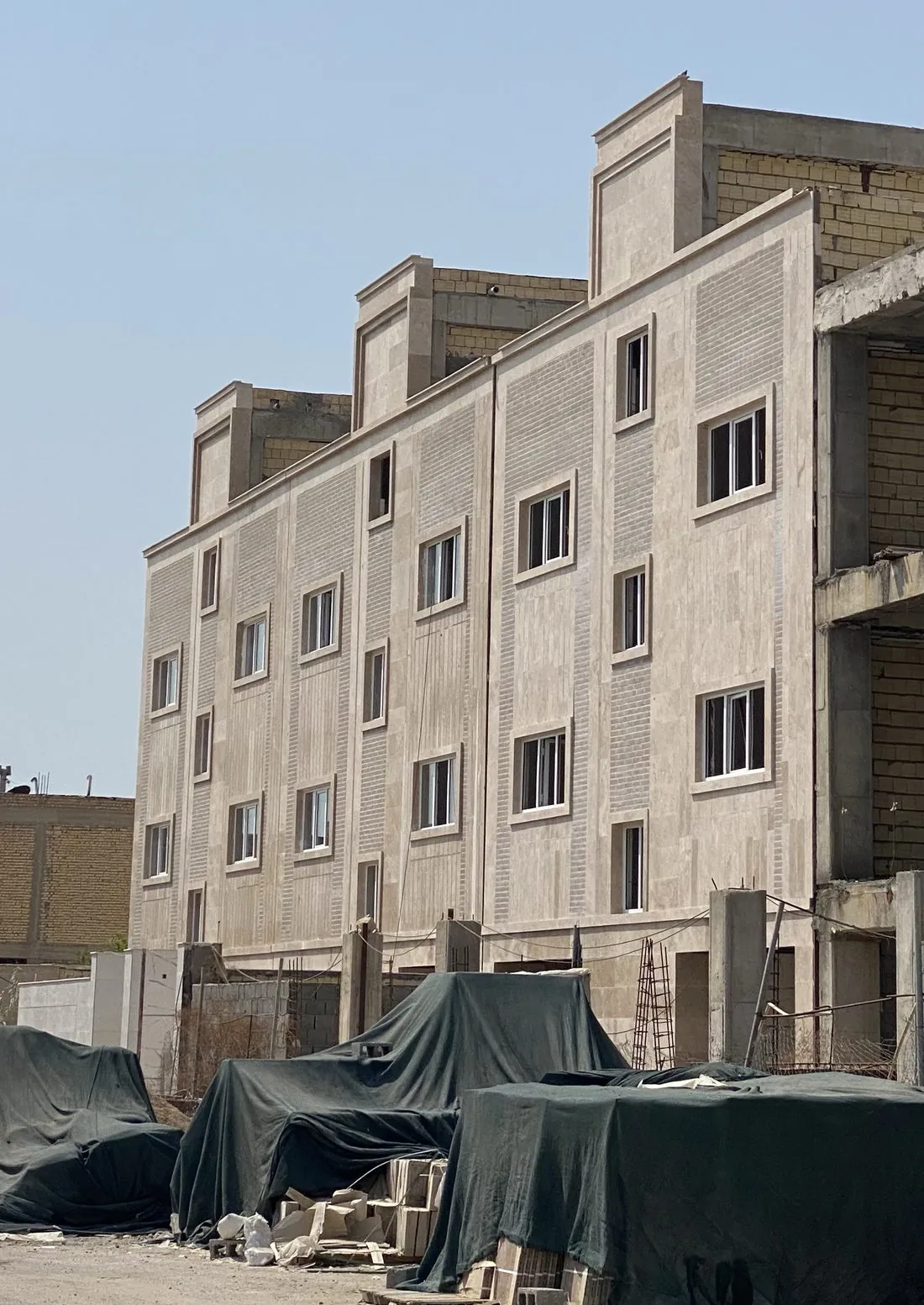 نمای سنگی با قاب پنجره‌ها در حال تکمیل - پروژه نهضت ملی